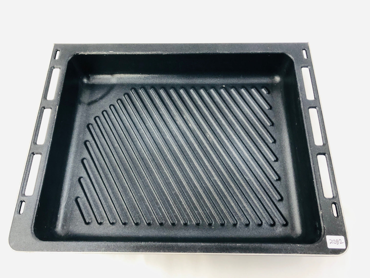 Black grill pan with ribbed surface on a white background